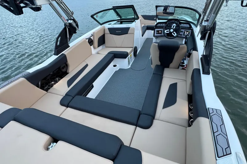 Slide: The Image of 2023 MasterCraft NXT22 boat interior with spacious seating and modern dashboard on water. - 24