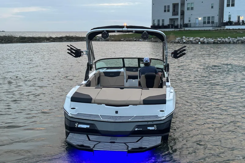 Slide: The Image of 2023 MasterCraft NXT22 boat on water, rear view with blue underwater lights. - 6