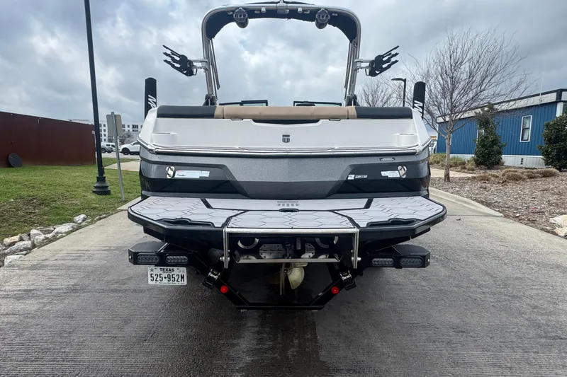 Slide: The Image of 2023 MasterCraft NXT22 boat rear view on a concrete ramp, overcast sky. - 8