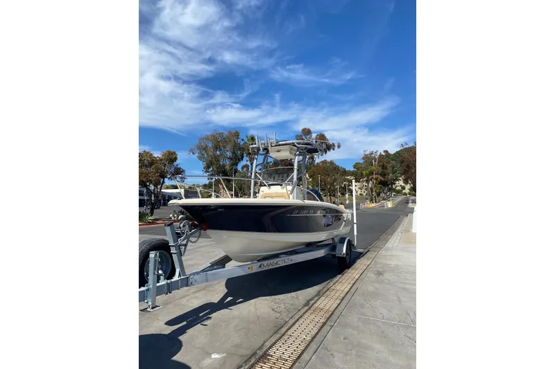 Slide: The Image of 2020 Scout 195 Sportfish boat on trailer under clear blue sky. - 14