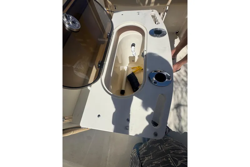 Slide: The Image of 2020 Scout 195 Sportfish boat interior with open storage compartment and fishing rod holders. - 24