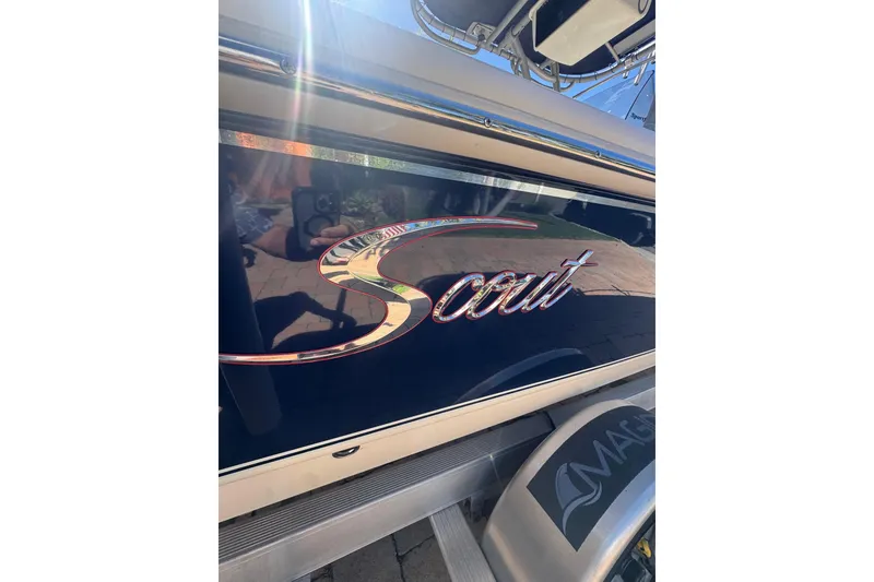 Slide: The Image of 2020 Scout 195 Sportfish boat with reflective logo and sleek design. - 25