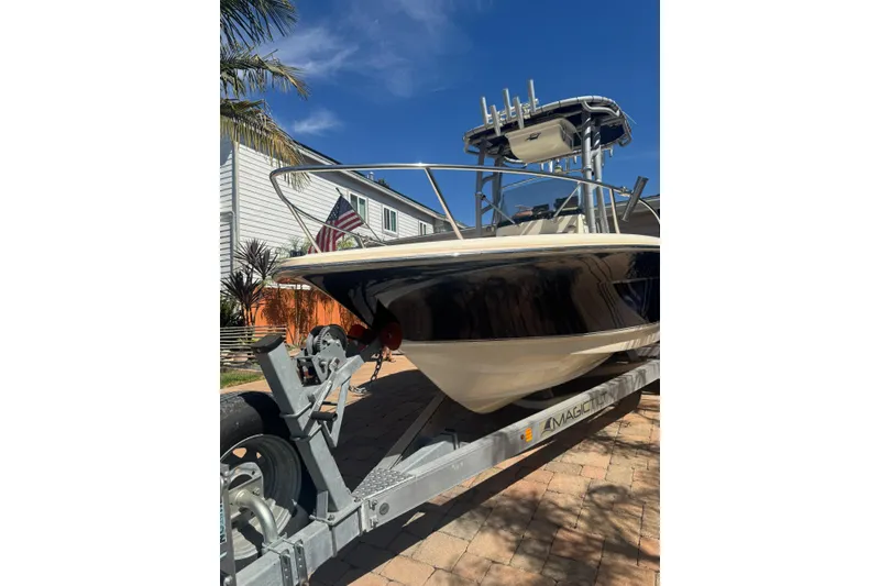 Slide: The Image of 2020 Scout 195 Sportfish boat on trailer, parked in sunny driveway. - 27