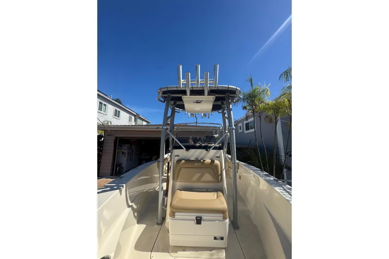 Slide: The Image of 2020 Scout 195 Sportfish boat with seating and T-top under clear blue sky. - 28