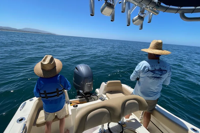 Slide: The Image of Two people fishing on a 2020 Scout 195 Sportfish boat in open water. - 33