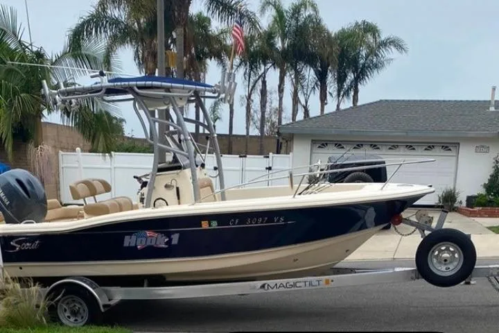 Slide: The Image of 2020 Scout 195 Sportfish boat on trailer, parked in residential area with palm trees. - 36