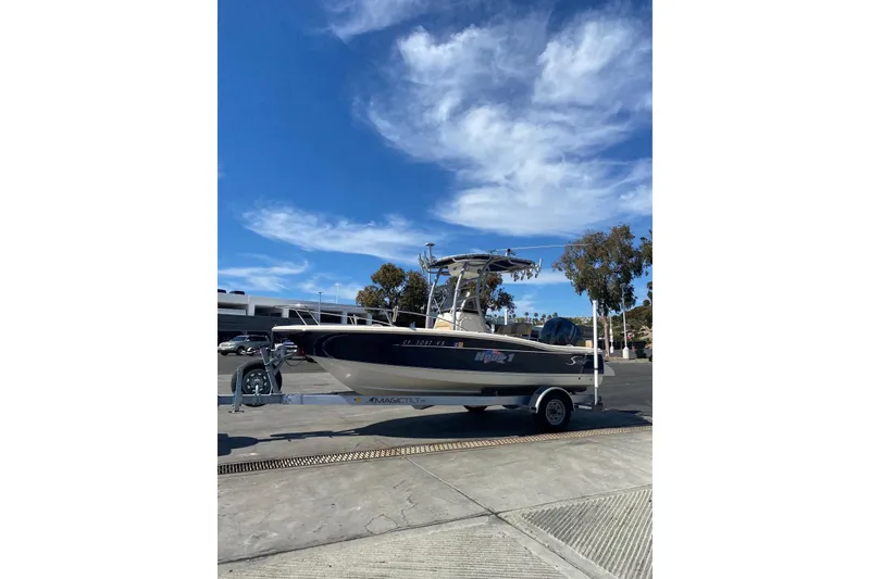 Slide: The Image of 2020 Scout 195 Sportfish boat on trailer under clear blue sky. - 5