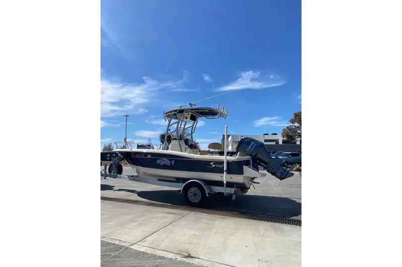 Slide: The Image of 2020 Scout 195 Sportfish boat on trailer under clear blue sky. - 8