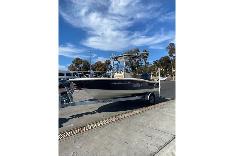 Slide: The Image of 2020 Scout 195 Sportfish boat on trailer under clear blue sky. - 9