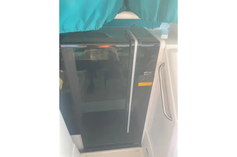 Slide: The Image of Fridge inside 1995 Carver 355 Aft Cabin Motor Yacht, with teal curtain backdrop. - 15