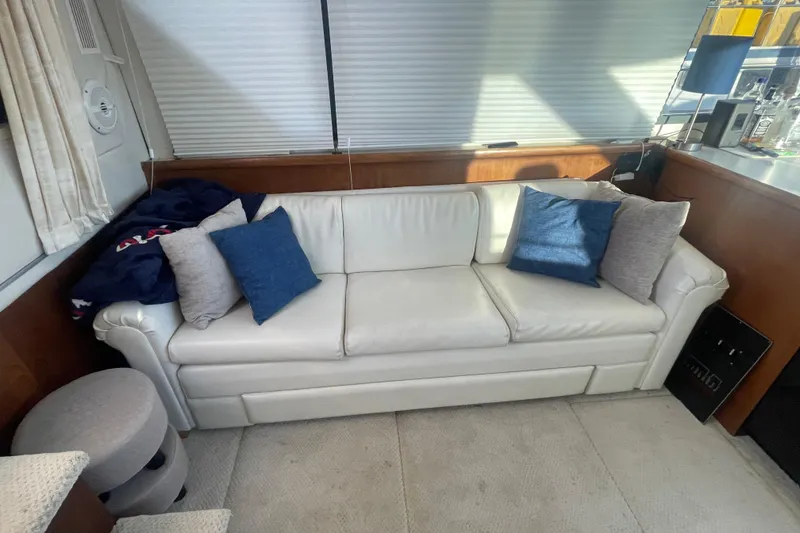 Slide: The Image of White leather sofa with blue and gray pillows in a 1995 Carver 355 Aft Cabin Motor Yacht. - 18
