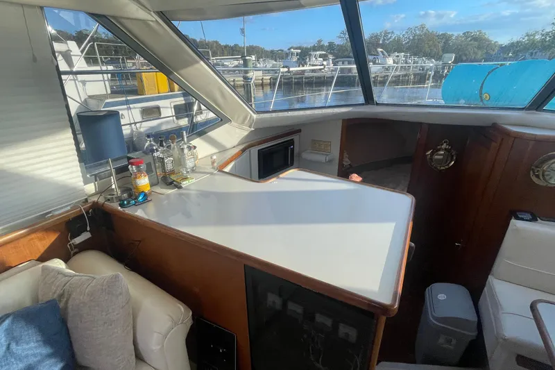 Slide: The Image of Interior of 1995 Carver 355 Aft Cabin Motor Yacht with bar setup and marina view. - 20