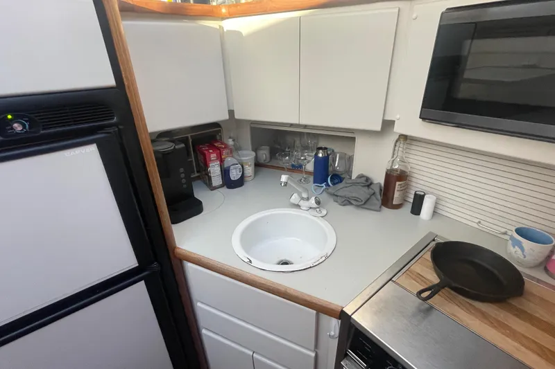 Slide: The Image of Compact kitchen in a 1995 Carver 355 Aft Cabin Motor Yacht with sink, microwave, and fridge. - 22