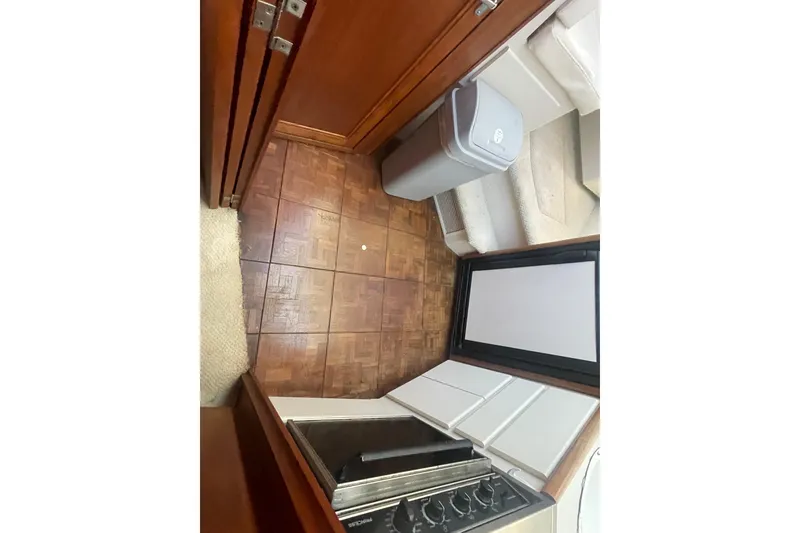 Slide: The Image of Interior of 1995 Carver 355 Aft Cabin Motor Yacht with wood flooring and compact kitchen. - 24