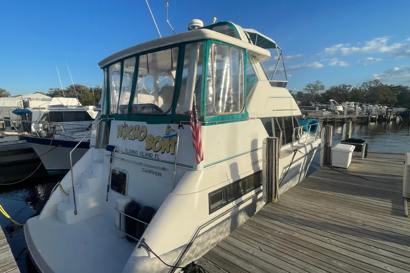 Slide: The Image of 1995 Carver 355 Aft Cabin Motor Yacht docked at marina under clear blue sky. - 3