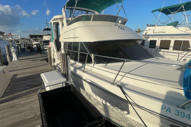 Slide: The Image of 1995 Carver 355 Aft Cabin Motor Yacht docked at marina under blue sky. - 4