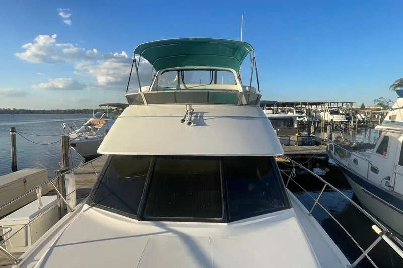 Slide: The Image of 1995 Carver 355 Aft Cabin Motor Yacht docked at marina under clear blue sky. - 6