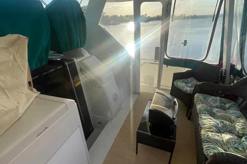 Slide: The Image of 1995 Carver 355 Aft Cabin Motor Yacht interior with seating and lake view. - 7