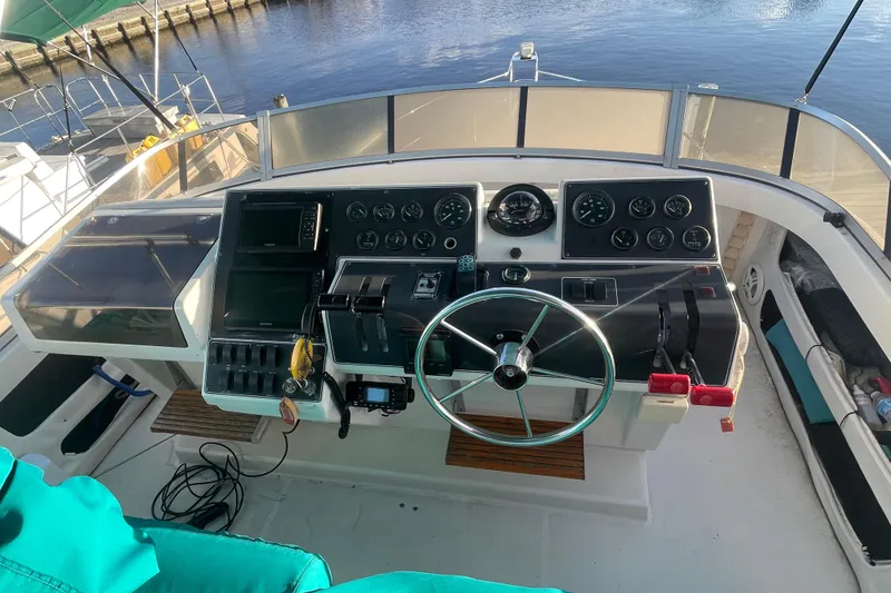 Slide: The Image of 1995 Carver 355 Aft Cabin Motor Yacht helm with steering wheel and control panel. - 9