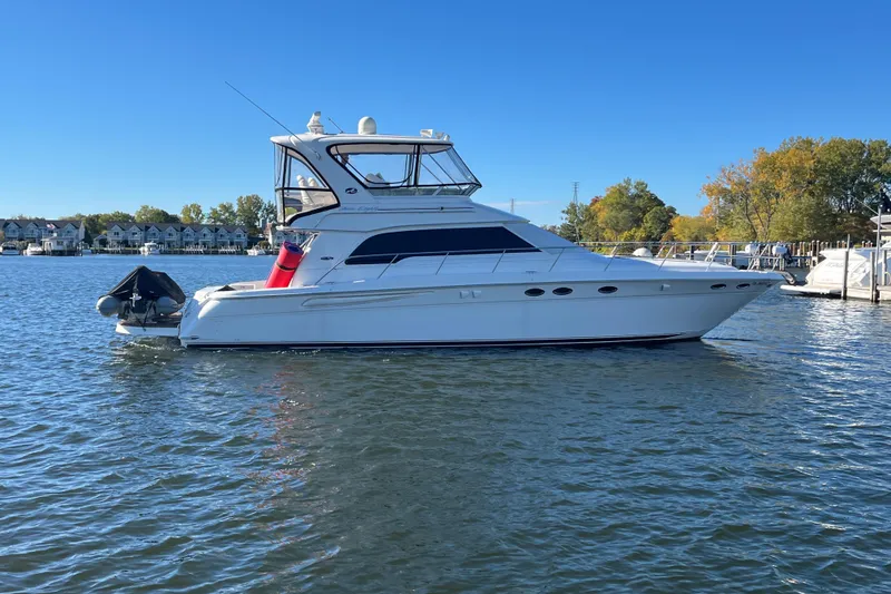 Slide: The Image of 2003 Sea Ray 480 Sedan Bridge yacht on calm water, clear sky background. - 30