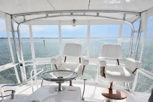 Slide: The Image of 2013 Hatteras GT54 yacht interior with cushioned seating and ocean view. - 19