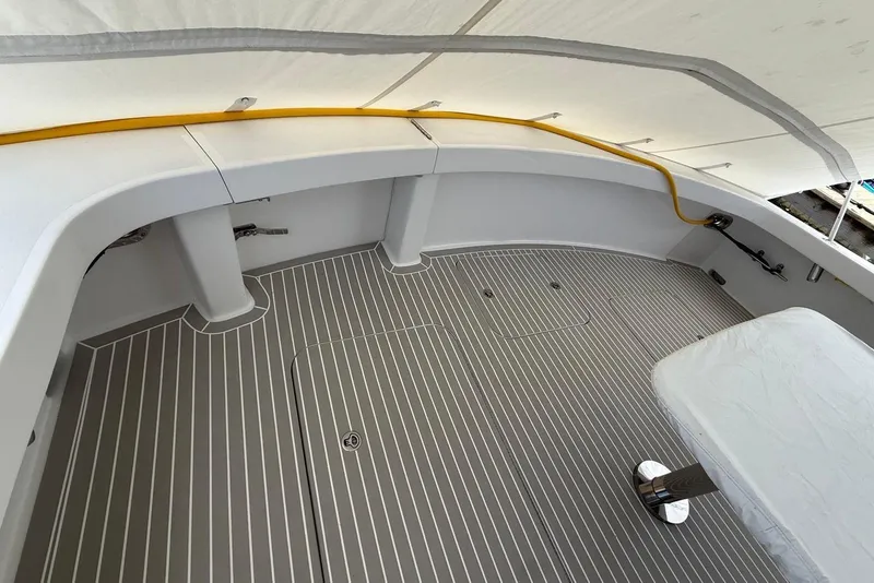 Slide: The Image of 2013 Hatteras GT54 boat deck with sleek, striped flooring and covered seating area. - 24