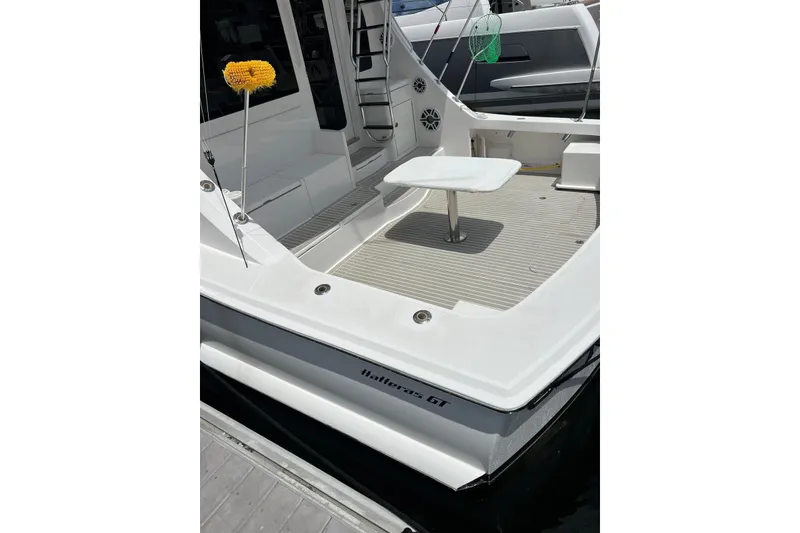 Slide: The Image of 2013 Hatteras GT54 yacht docked, featuring sleek design and American flag. - 28