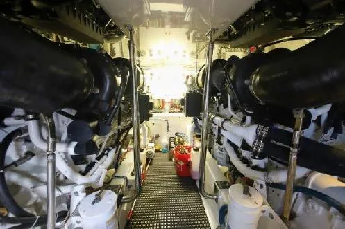 Slide: The Image of Engine room of 2013 Hatteras GT54 yacht, featuring mechanical components and piping. - 30