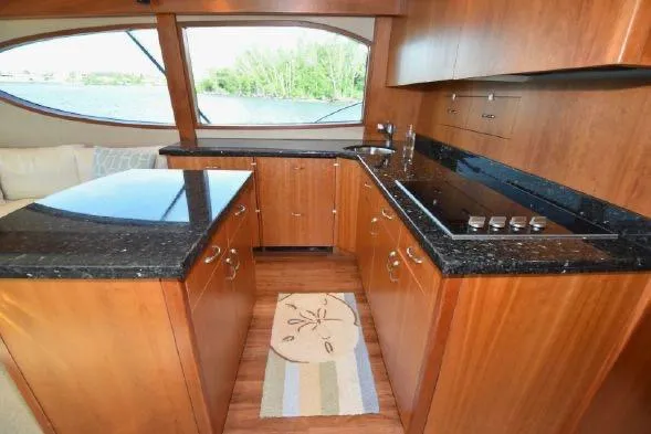 Slide: The Image of Luxurious interior of 2013 Hatteras GT54 yacht with sleek wooden cabinetry and granite countertops. - 8