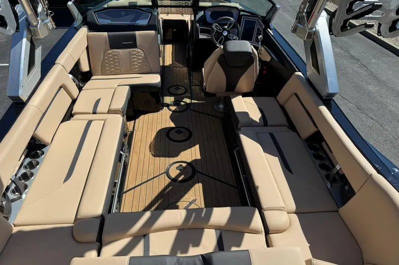 Slide: The Image of 2022 MasterCraft X24 boat interior with beige seating and modern dashboard. - 12