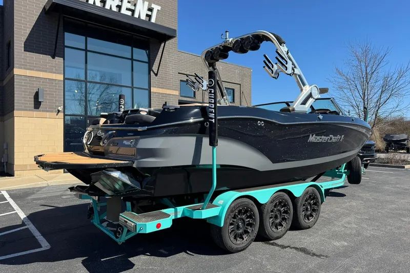 Slide: The Image of 2022 MasterCraft X24 boat on trailer outside a modern building. - 3