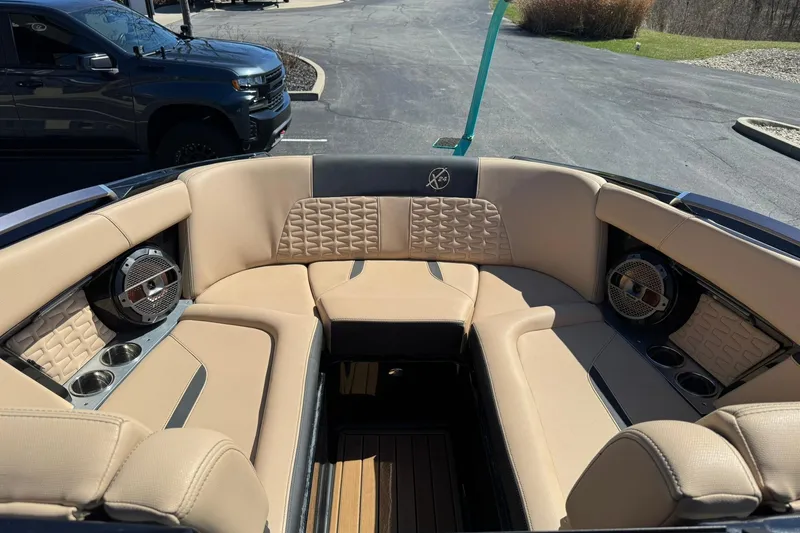Slide: The Image of 2022 MasterCraft X24 boat interior with beige seating and built-in speakers. - 8