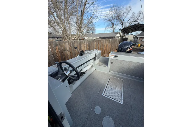 Slide: The Image of 2022 Hewescraft 220 Ocean Pro Hardtop boat interior with steering wheel and outboard motor. - 11