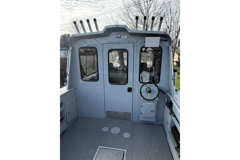 Slide: The Image of 2022 Hewescraft 220 Ocean Pro Hardtop boat interior with steering wheel and rod holders. - 14