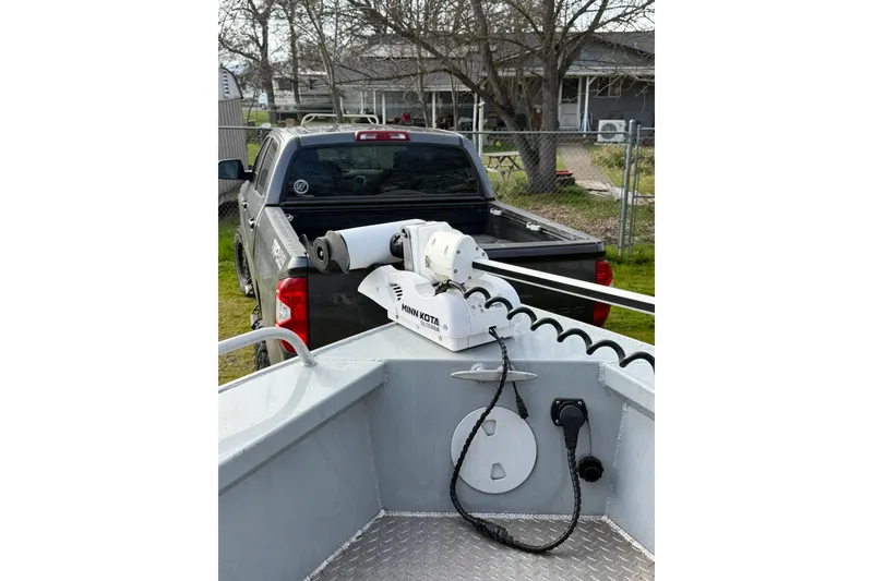 Slide: The Image of 2022 Hewescraft 220 Ocean Pro Hardtop with Minn Kota motor, parked near a pickup truck. - 16