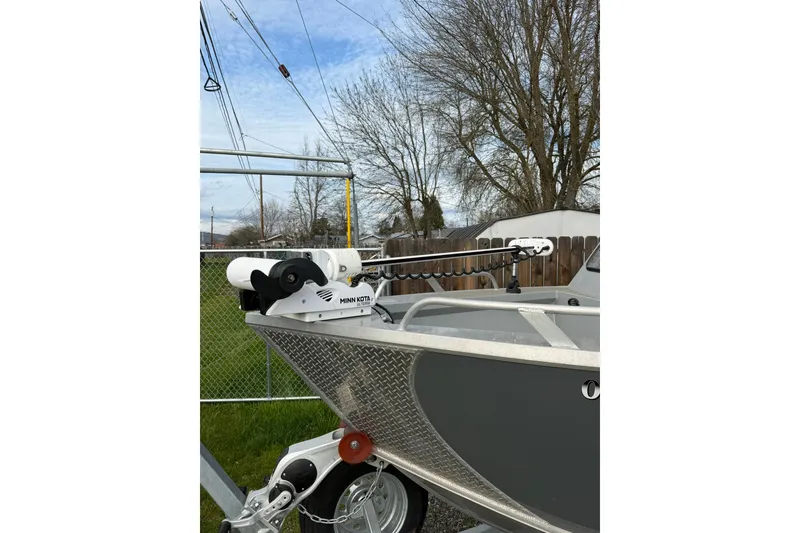 Slide: The Image of 2022 Hewescraft 220 Ocean Pro Hardtop with Minn Kota motor, parked outdoors. - 18