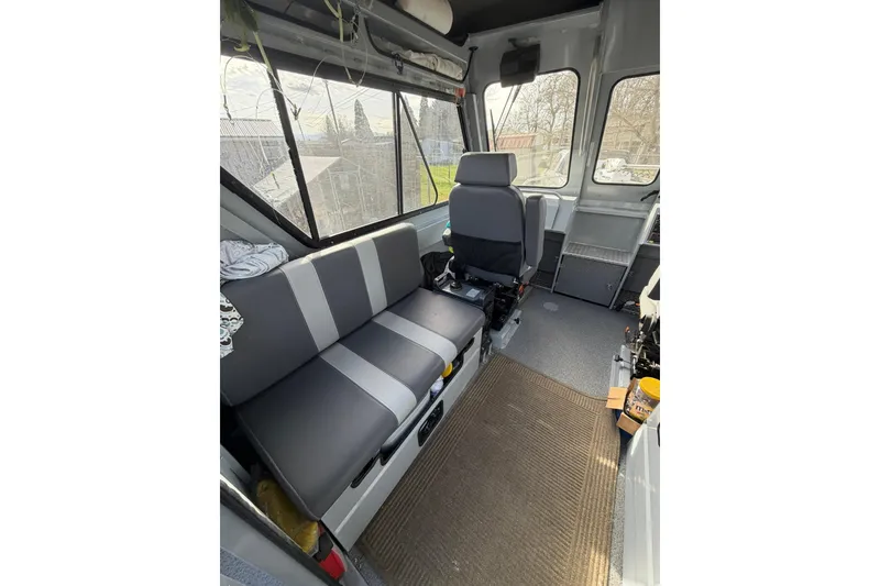 Slide: The Image of Interior of 2022 Hewescraft 220 Ocean Pro Hardtop, featuring seating and windows. - 4