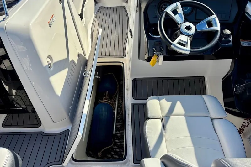 Slide: The Image of 2016 Yamaha Boats AR240 HO interior with steering wheel, storage compartment, and seating. - 25
