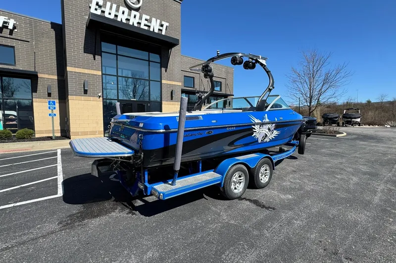 Slide: The Image of 2011 Centurion Avalanche C4 boat on trailer outside a building under clear blue sky. - 3