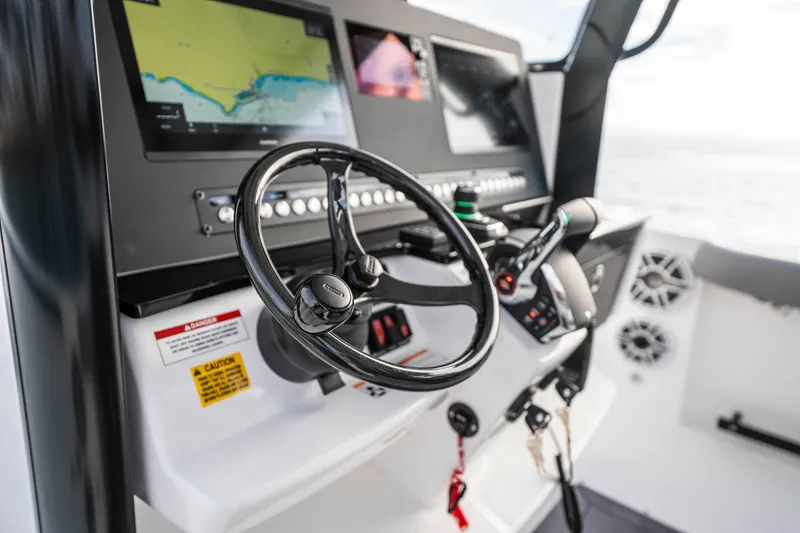 Slide: The Image of 2024 Everglades 365 Center Console boat dashboard with steering wheel and navigation screens. - 105