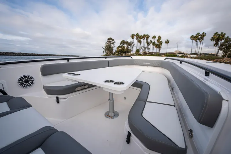 Slide: The Image of 2024 Everglades 365 Center Console boat with spacious seating and table, coastal background. - 109