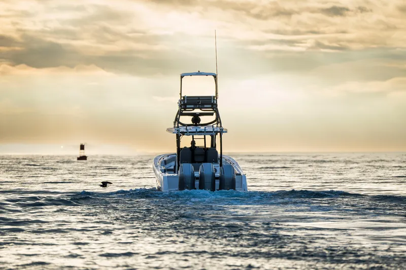 Slide: The Image of 2024 Everglades 365 Center Console boat cruising at sunset on open water. - 14