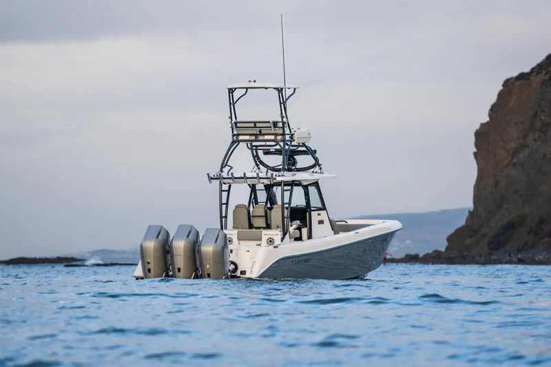 Slide: The Image of 2024 Everglades 365 Center Console boat on water near rocky coastline. - 16