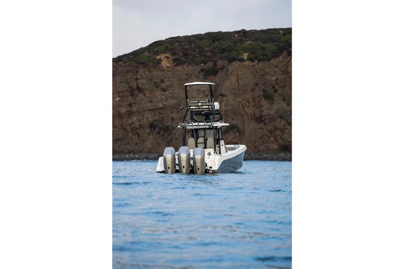 Slide: The Image of 2024 Everglades 365 Center Console boat on water, rocky coastline background. - 17