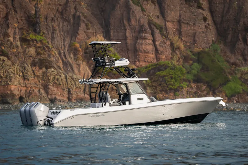 Slide: The Image of 2024 Everglades 365 Center Console boat on water, rocky cliffs in background. - 2