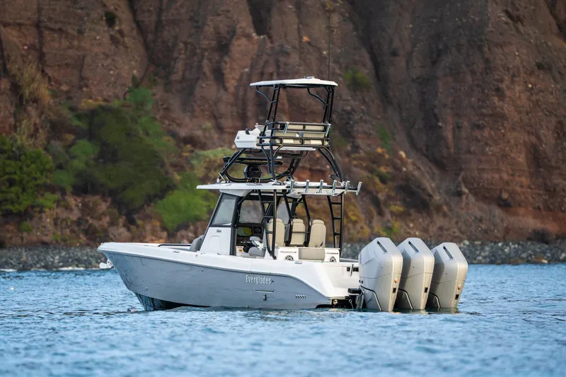 Slide: The Image of 2024 Everglades 365 Center Console boat with triple engines on scenic water. - 20