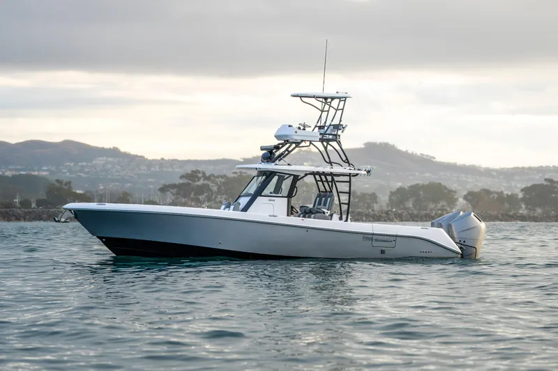 Slide: The Image of 2024 Everglades 365 Center Console boat on calm water, scenic background. - 21