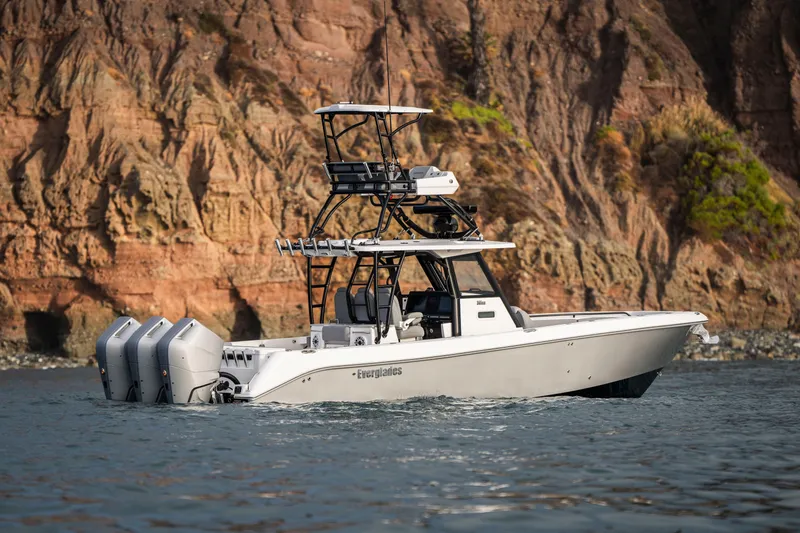 Slide: The Image of 2024 Everglades 365 Center Console boat cruising near rocky cliffs. - 33