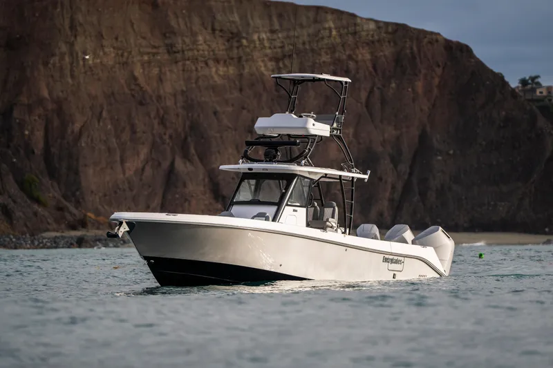 Slide: The Image of 2024 Everglades 365 Center Console boat cruising near rocky coastline. - 38