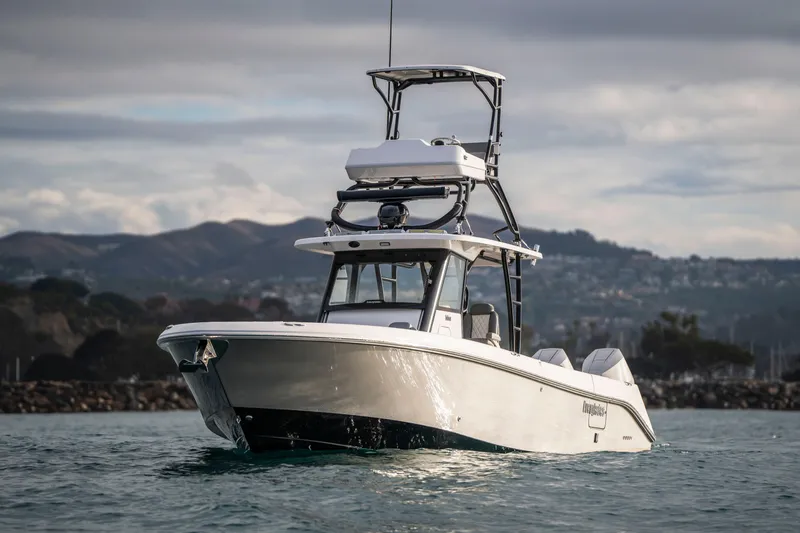 Slide: The Image of 2024 Everglades 365 Center Console boat on water with scenic mountain backdrop. - 39